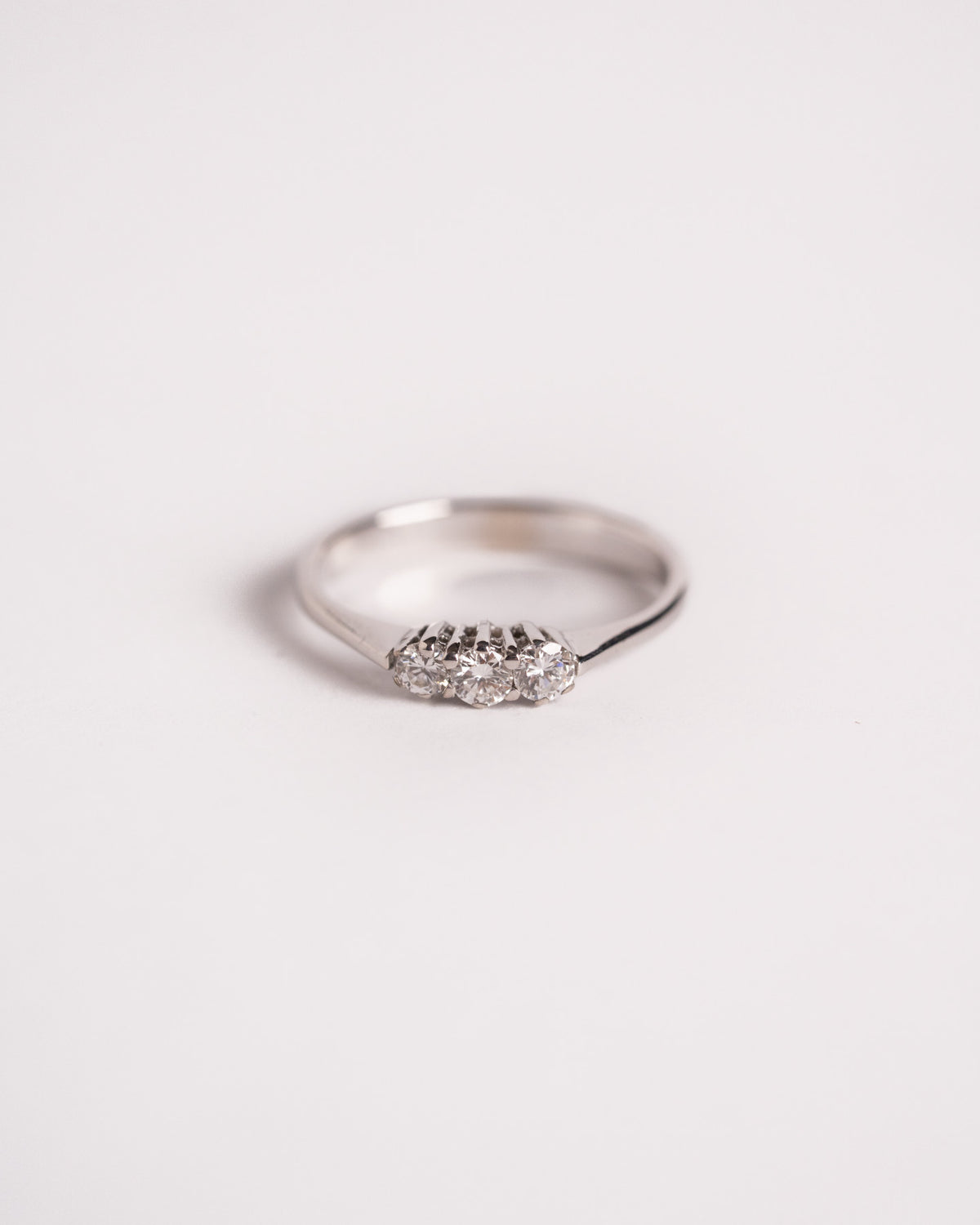 Anello trilogy diamanti in oro bianco con tre pietre tonde allineate, still life su fondo chiaro, Gioielleria La Rosa