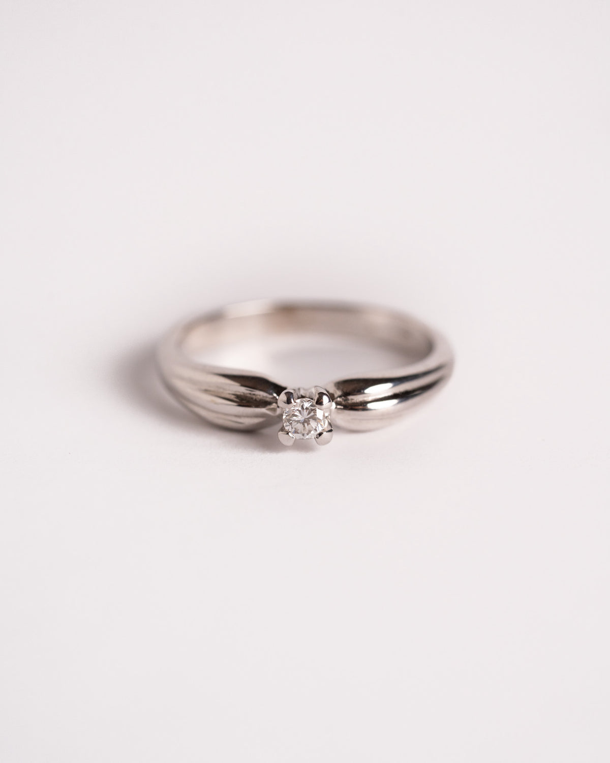 Anello solitario diamante oro bianco Fiocco di Luce, still life su fondo chiaro, Gioielleria La Rosa