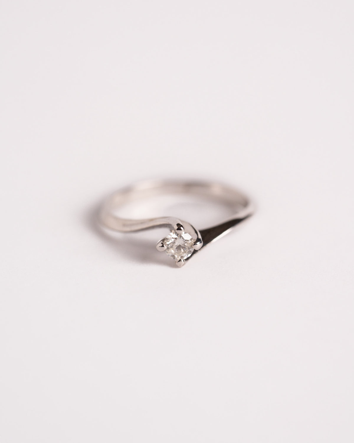 Anello solitario Carezza di Diamante in oro bianco con diamante da 0,15 ct, still life su fondo chiaro, Gioielleria La Rosa