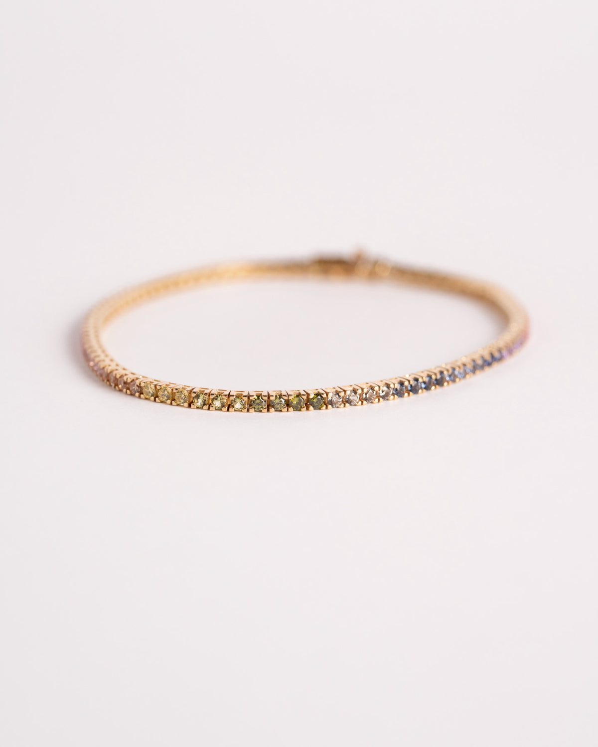 Bracciale tennis corindoni colorati in oro giallo 750, still life su fondo chiaro, Gioielleria La Rosa
