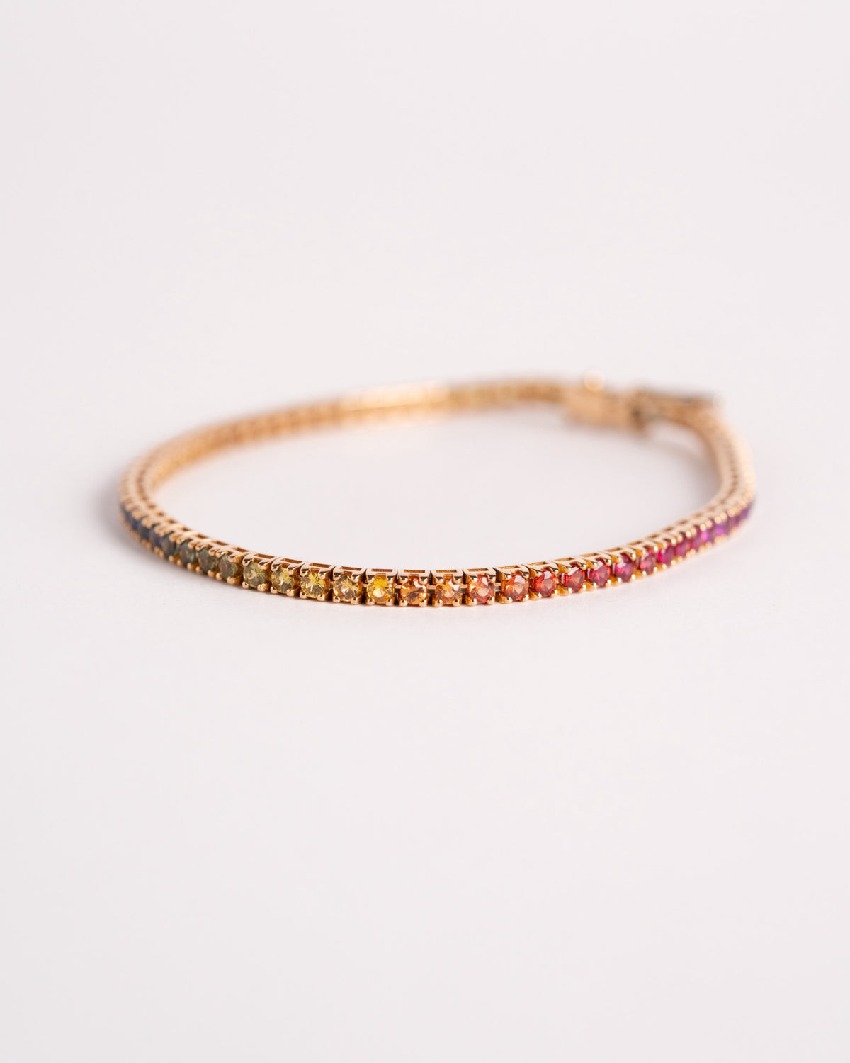 Bracciale tennis rainbow in oro giallo 750 da uomo con 72 pietre colorate, still life su fondo chiaro, Gioielleria La Rosa