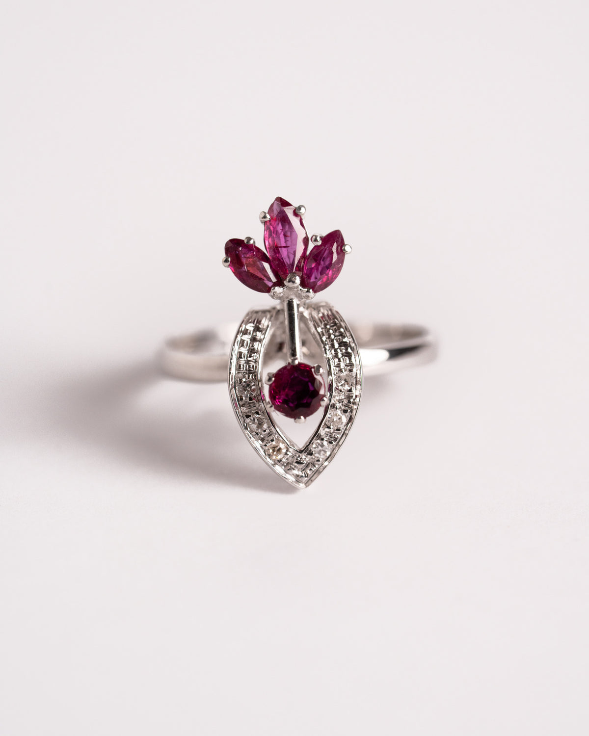 Anello Fiamma di Rubini con tre rubini marquise, rubino tondo e brillanti in oro bianco, still life su fondo chiaro