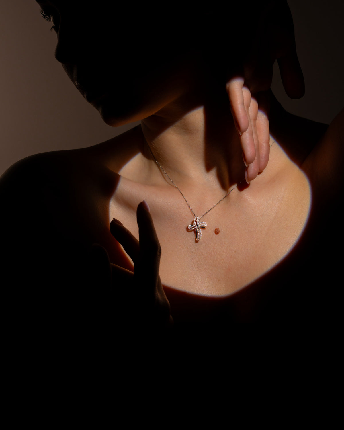 Collana con croce in oro bianco e diamanti indossata sul décolleté con catena sottile, Gioielleria La Rosa