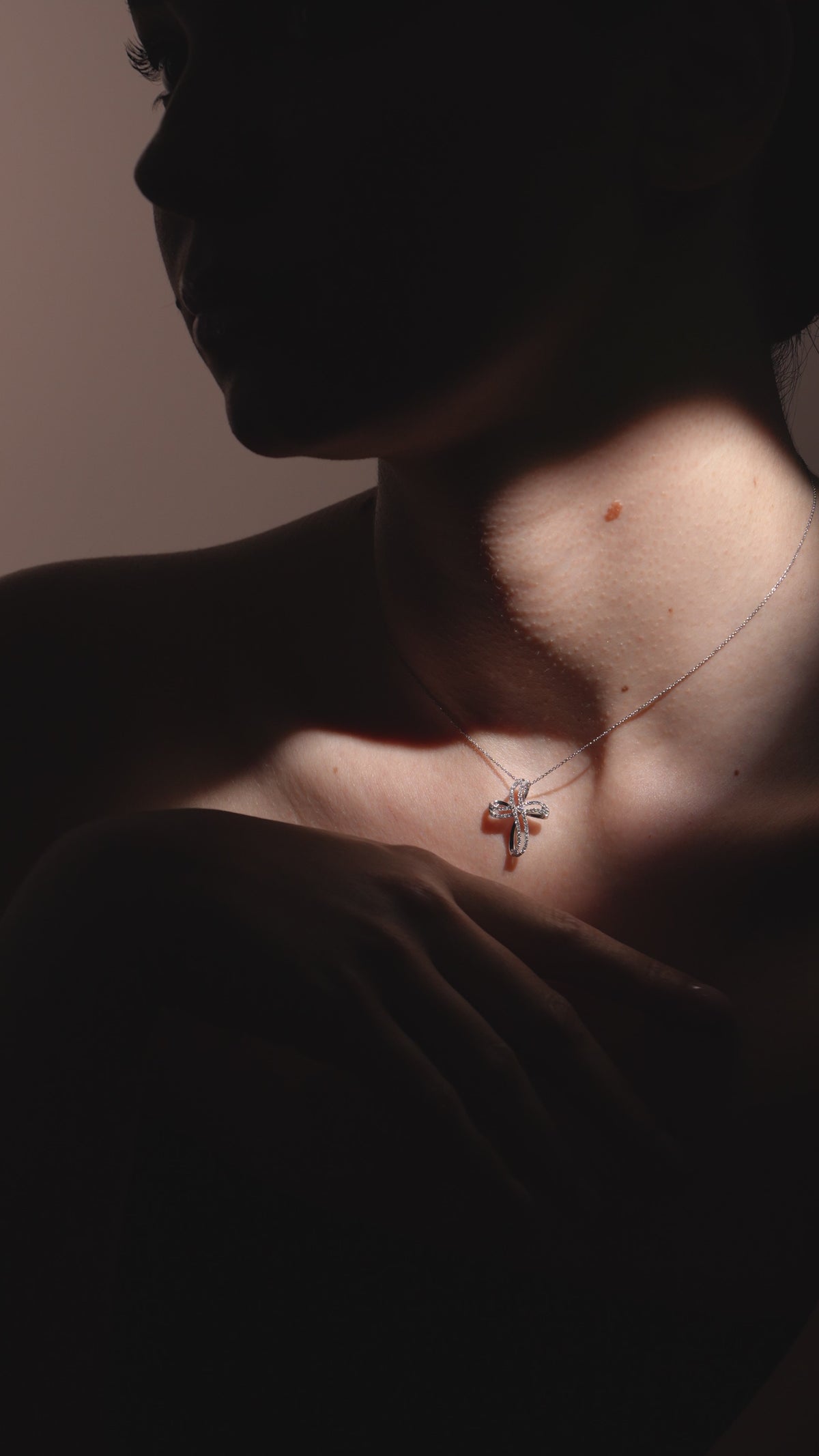 Video della croce contemporanea in oro bianco e diamanti indossata sul décolleté