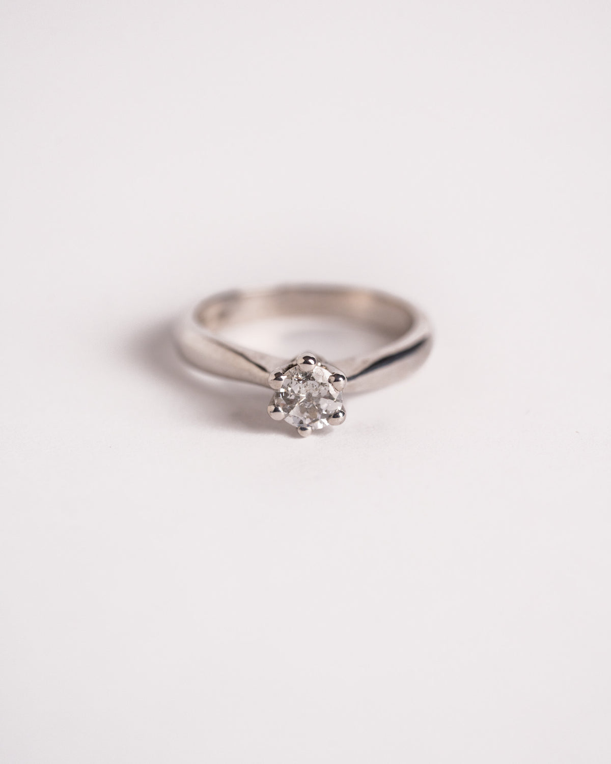 Anello solitario con diamante 0,25 ct a cinque punte in oro bianco 18 carati, still life su fondo chiaro, Gioielleria La Rosa