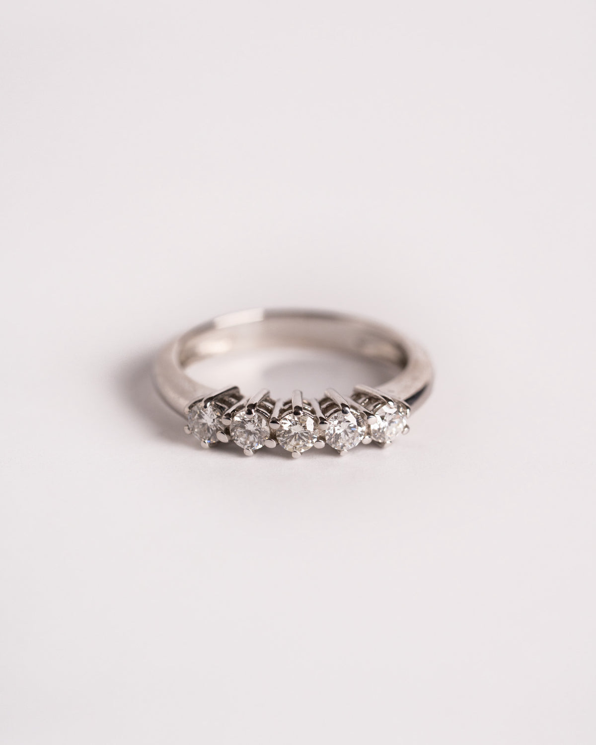 Anello veretta con 5 diamanti in oro bianco 18 carati montati a griffe, still life su fondo chiaro, Gioielleria La Rosa