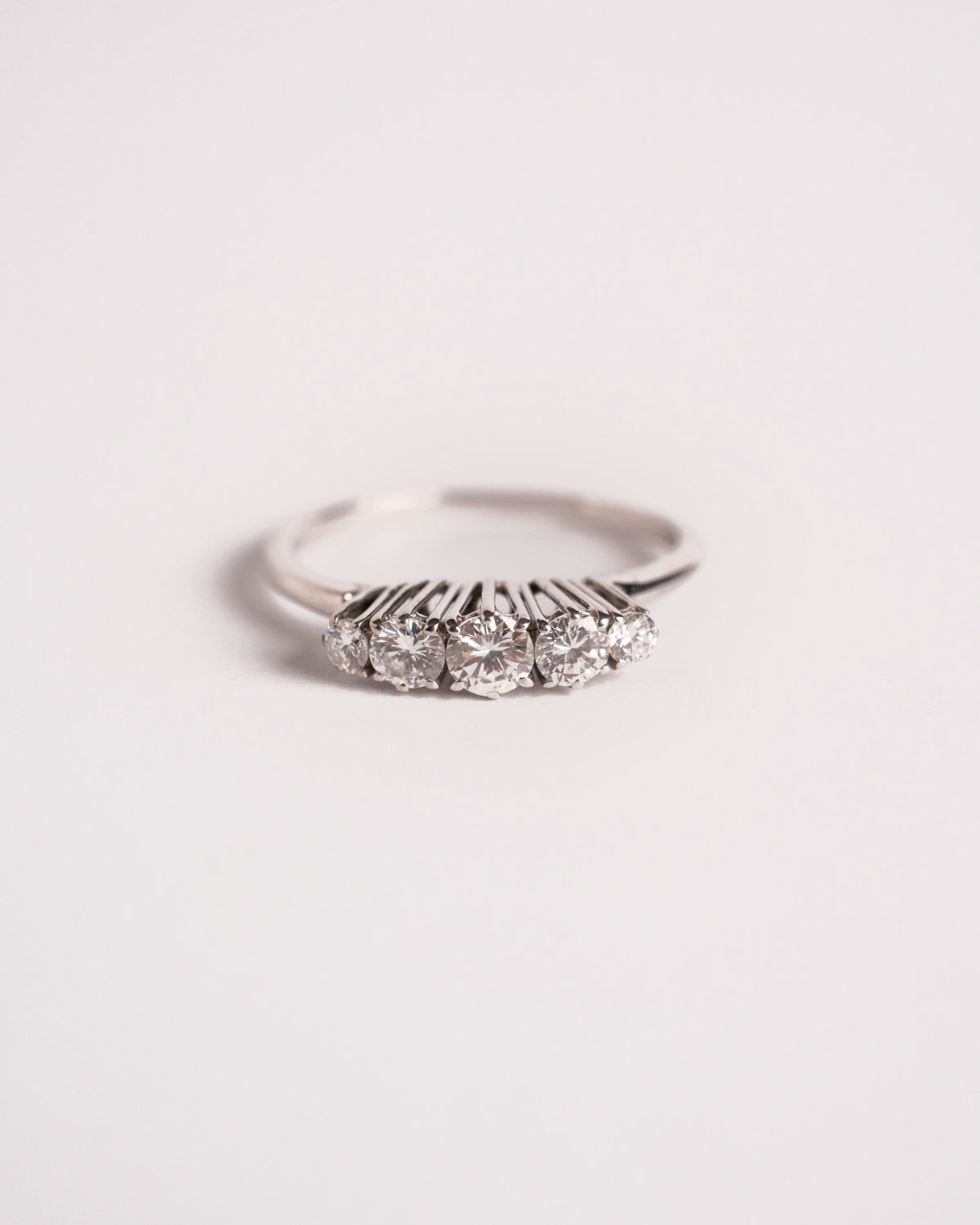 Anello veretta a griffe alte con 5 diamanti degradé in oro bianco 18 carati, still life su fondo chiaro, Gioielleria La Rosa