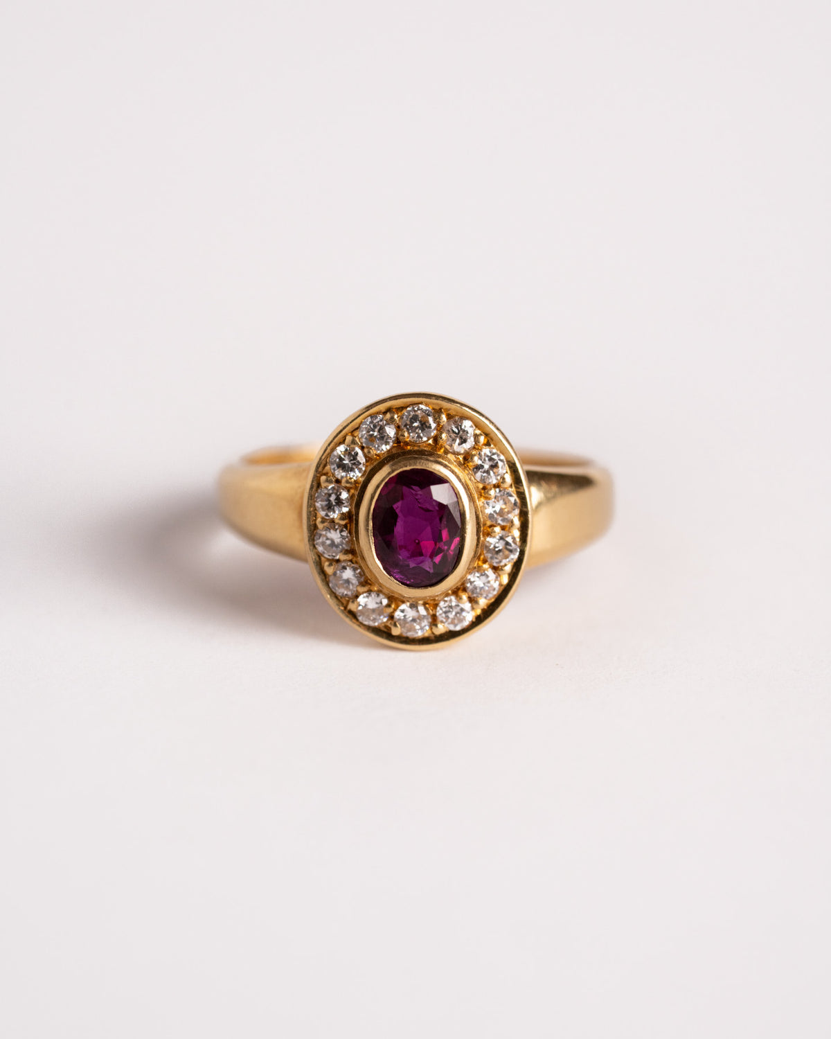 Anello con rubino e diamanti in oro giallo 18 carati, still life su fondo chiaro, Gioielleria La Rosa