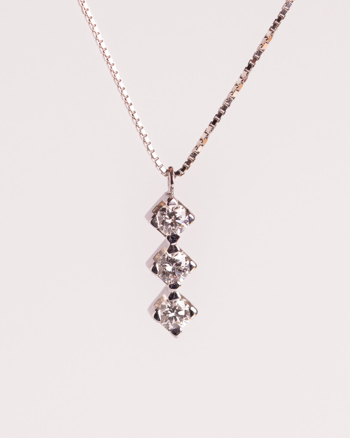Collana trilogy con diamanti in oro bianco 18 carati su catena veneziana, still life su fondo chiaro, Gioielleria La Rosa